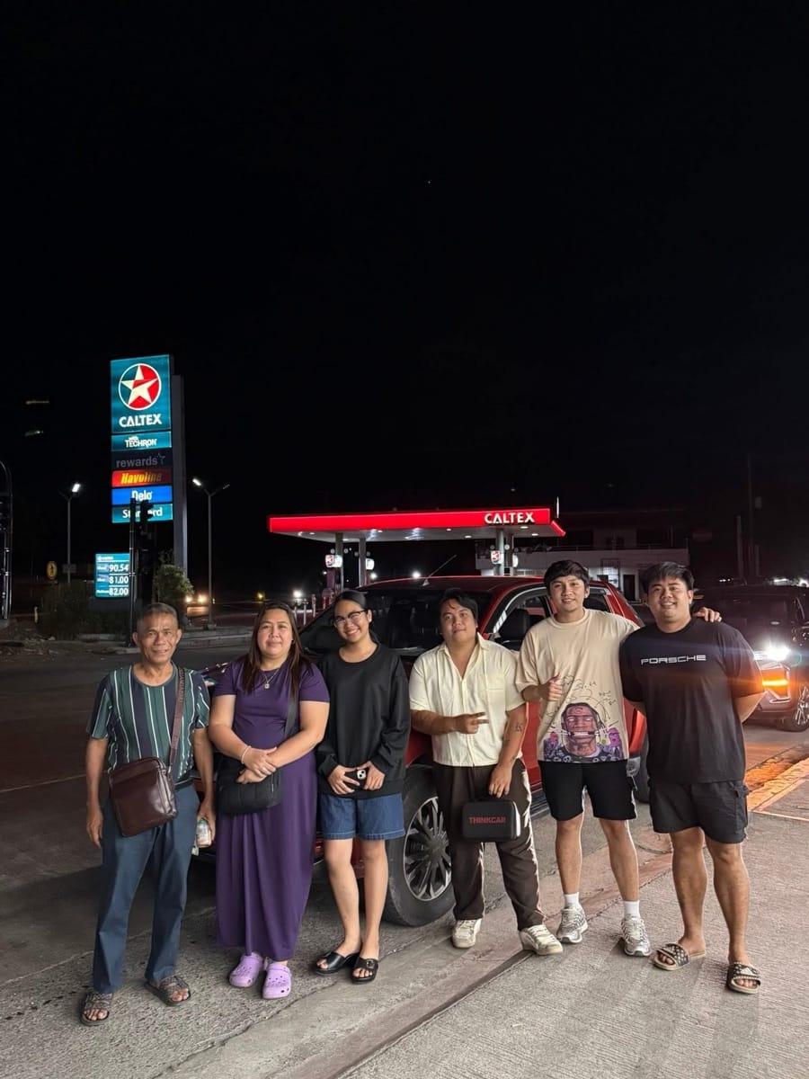 Buyers with their SUV during an evening handoff at a fuel stop
