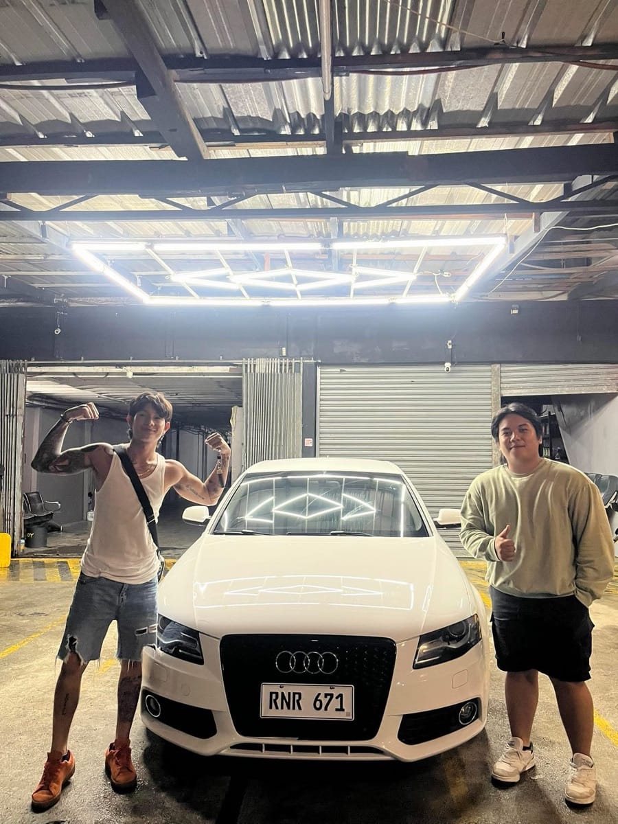 New owner celebrating beside a white Audi A4